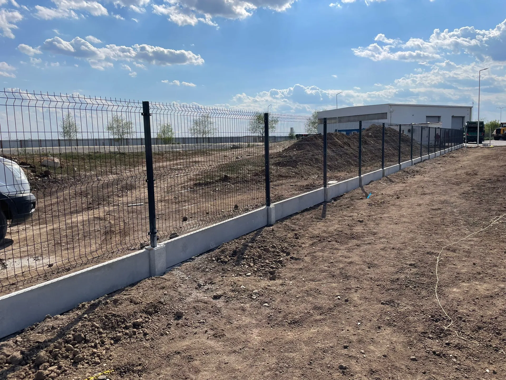 Proiectul de împrejmuire completă cu soclu prefabricat realizat de Rom Waste reprezintă o soluție modernă și eficientă pentru delimitarea și securizarea spațiilor industriale. Acest proiect a implicat utilizarea unor panouri bordurate robuste, combinate cu socluri prefabricate din PVC, oferind un aspect uniform și o durabilitate crescută.

Soclurile prefabricate din PVC, utilizate în acest proiect, sunt o alternativă inovatoare la fundațiile tradiționale din beton. Acestea sunt ușor de instalat, nu necesită lucrări de betonare și sunt rezistente la intemperii, ceea ce le face ideale pentru proiecte care necesită o implementare rapidă și eficientă【4:0†source】.

Panourile bordurate, zincate la cald, asigură o protecție excelentă împotriva coroziunii și oferă o structură solidă, capabilă să reziste în condiții variate de mediu【4:5†source】.