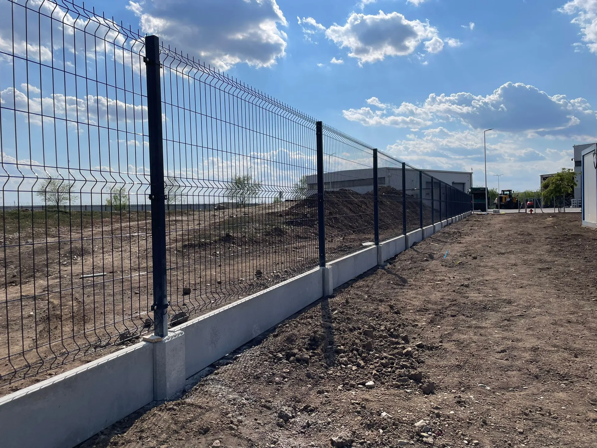 Proiectul de împrejmuire completă cu soclu prefabricat realizat de Rom Waste reprezintă o soluție modernă și eficientă pentru delimitarea și securizarea spațiilor industriale. Acest proiect a implicat utilizarea unor panouri bordurate robuste, combinate cu socluri prefabricate din PVC, oferind un aspect uniform și o durabilitate crescută.

Soclurile prefabricate din PVC, utilizate în acest proiect, sunt o alternativă inovatoare la fundațiile tradiționale din beton. Acestea sunt ușor de instalat, nu necesită lucrări de betonare și sunt rezistente la intemperii, ceea ce le face ideale pentru proiecte care necesită o implementare rapidă și eficientă【4:0†source】.

Panourile bordurate, zincate la cald, asigură o protecție excelentă împotriva coroziunii și oferă o structură solidă, capabilă să reziste în condiții variate de mediu【4:5†source】.